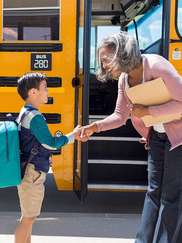 Image of polite child getting onto school bus.
