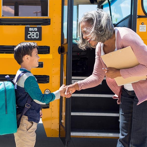 Image of polite child getting onto school bus.