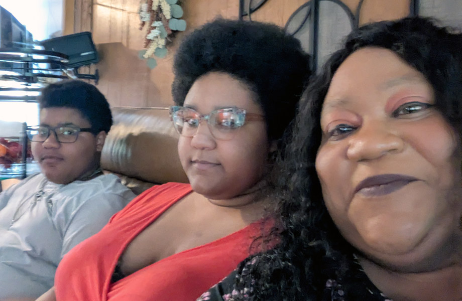 Ebony Boatman taking a selfie-style photo of herself and her 2 children all sitting together on a couch