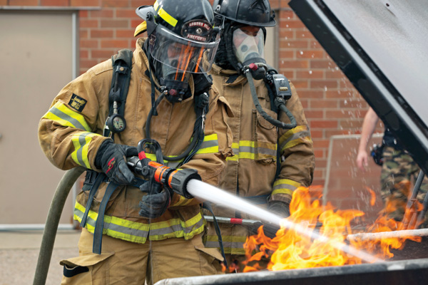 OCC student putting out fire with fire hose as part of OCC programs that train first responders.