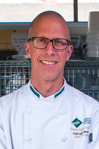 Chef Greg Stroker Chef Greg Stroker posing for a headshot photo, wearing a chef coat