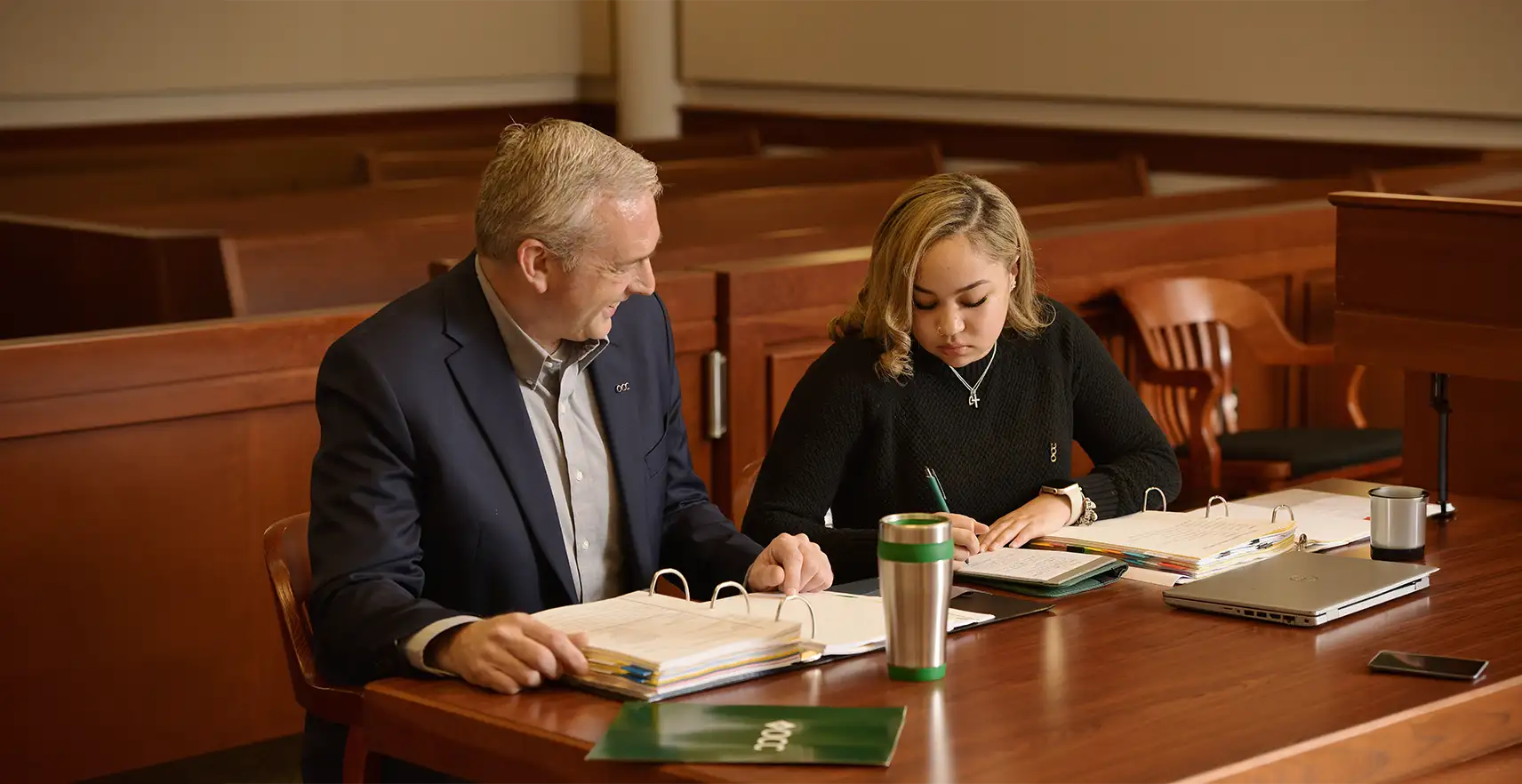 Photo of a lawyer and paralegal student in a courtroom