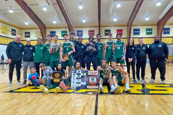 The OCC men's basketball team poses with its district championship trophy.