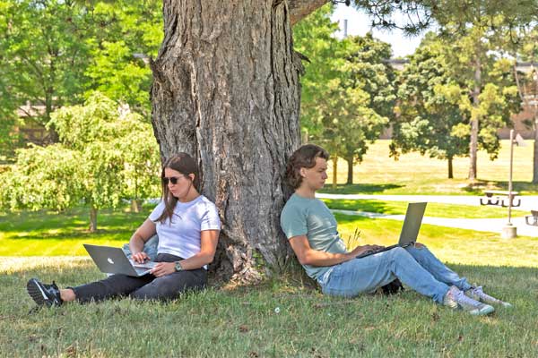 Two students under a tree.