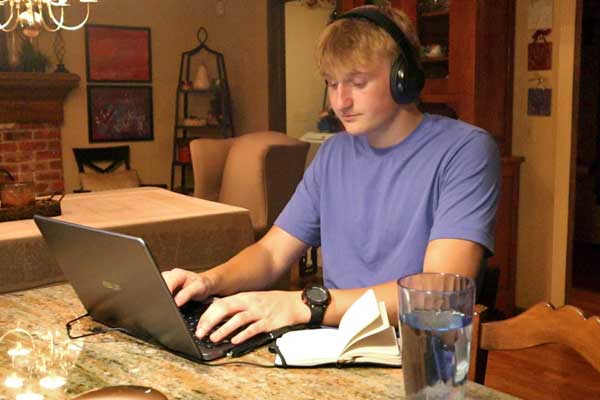 A student studying at home using a laptop.