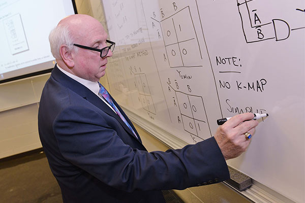 Pre-Engineering Program Directory, James O'Connor, writing out equations on a whiteboard