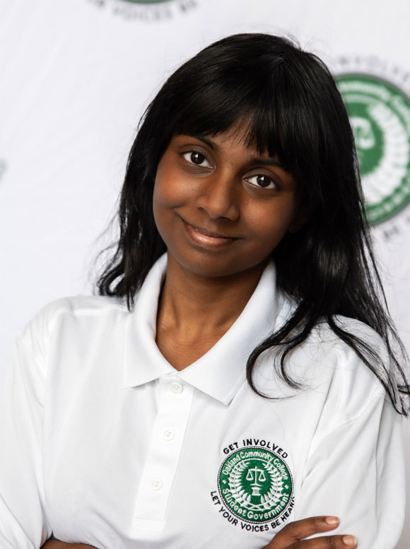 Hadassah Pulidindi Portrait of a young woman wearing a white polo shirt with a student government logo